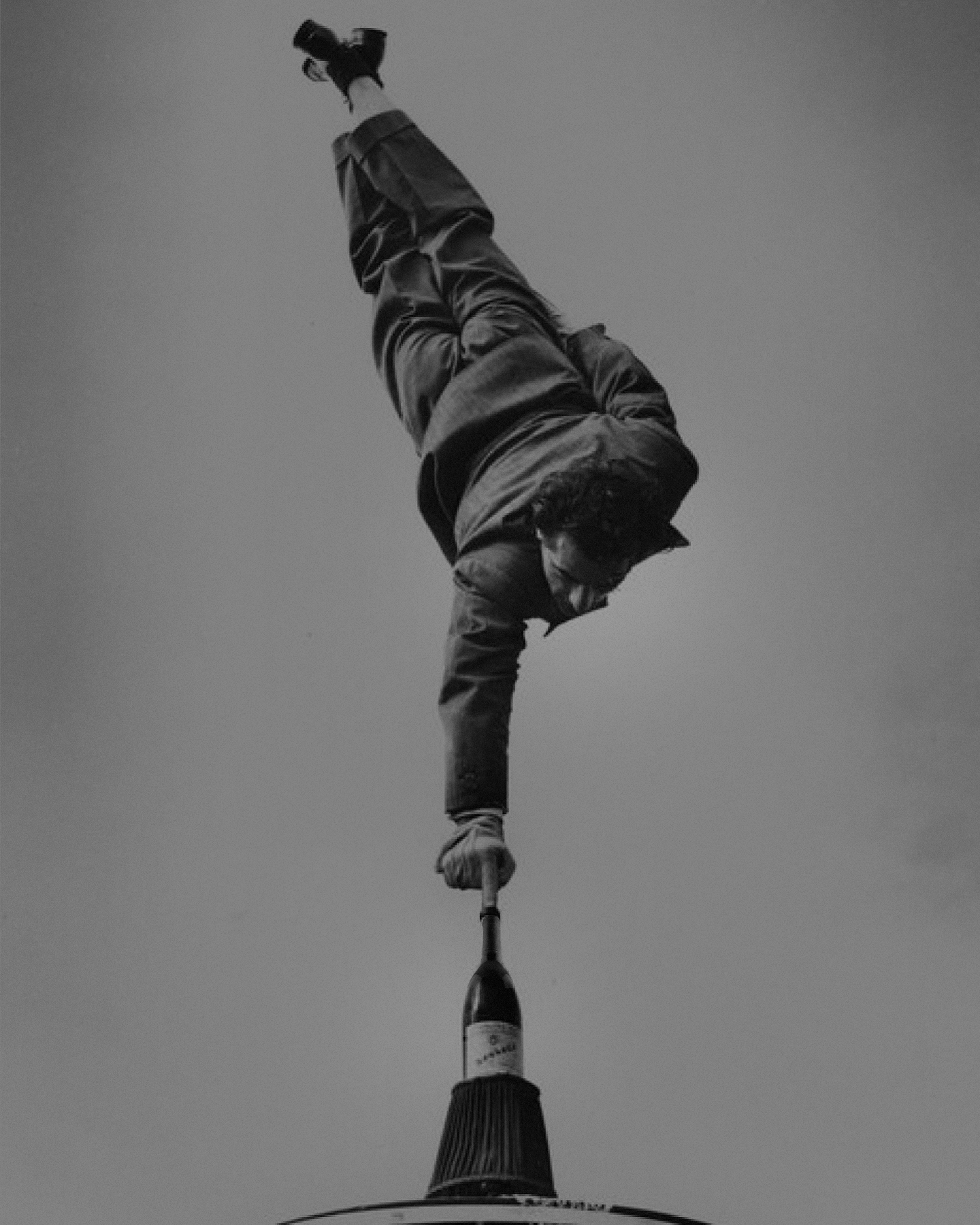 A circus artist juggling on top of a Rioja wine bottle.