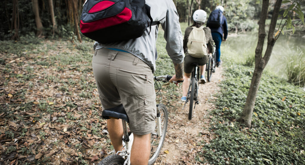 Group of friends ride mountain bike in the forest together