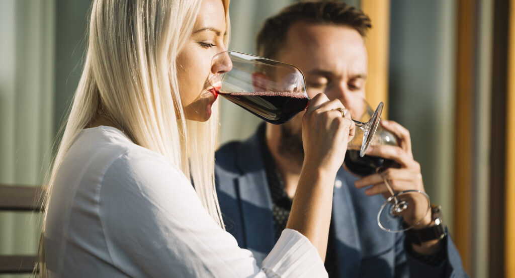 rubia-joven-y-su-novio-bebiendo-copa-de-vino-tinto